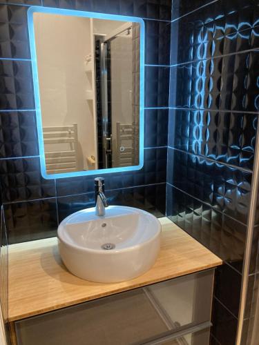 uma casa de banho com um lavatório branco e um espelho. em Superbe Chalet à Megève 7 pers Près des Pistes em Demi-Quartier