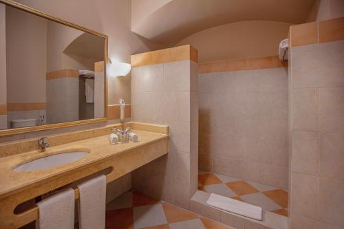 a bathroom with a sink and a mirror at Jaz Makadi Saraya Resort in Hurghada