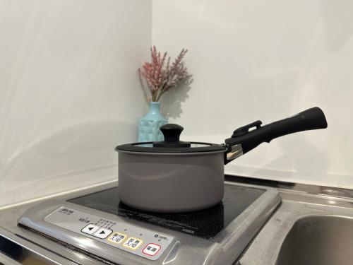 a pot sitting on top of a stove at nestay inn tokyo kagurazaka in Tokyo
