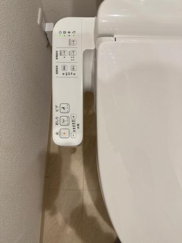 a close up of a toilet with a remote control at nestay inn tokyo kagurazaka in Tokyo
