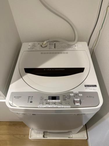 a washing machine with a cord on top of it at nestay inn tokyo kagurazaka in Tokyo