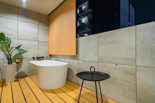 a bathroom with a tub and a table at Randor Hotel Hiroshima Prestige in Hiroshima