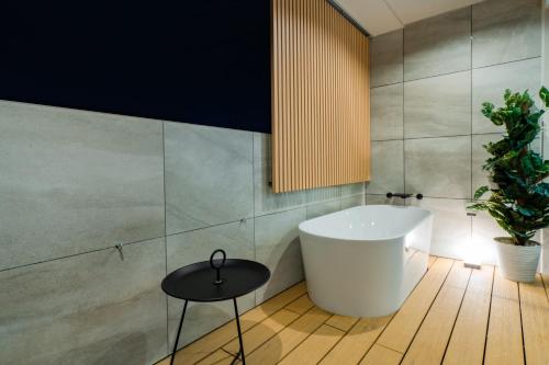 a bathroom with a tub and a table and a plant at Randor Hotel Hiroshima Prestige in Hiroshima