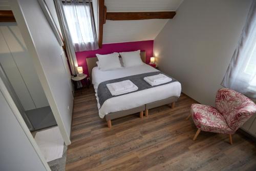 ein kleines Schlafzimmer mit einem Bett und einem Stuhl in der Unterkunft L'Appart de La Grande Boutique du Vin Beaune in Beaune