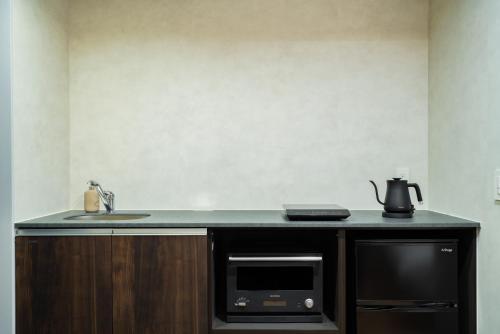 a kitchen counter with a sink and a microwave at Randor Hotel Hiroshima Prestige in Hiroshima