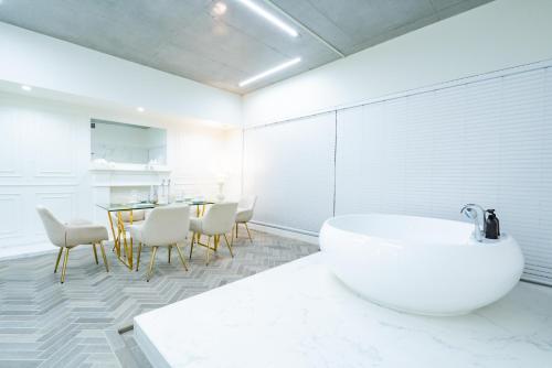 a bathroom with a tub and a table and chairs at Randor Hotel Hiroshima Prestige in Hiroshima