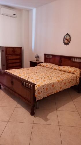 ein Schlafzimmer mit einem Bett mit einem Holzrahmen in der Unterkunft Appartamento Maria in Galatone