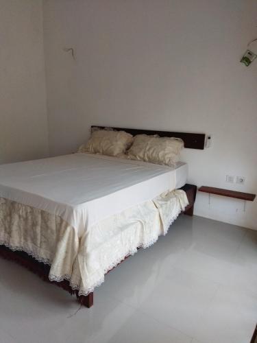 een bed met witte lakens en kussens in een kamer bij Pakok homestay in Kuta Lombok