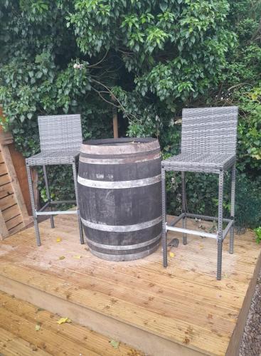 a barrel and two chairs on a wooden deck at Modern Retreat Near Town & Nature with Stunning Views Entertainment and Parking in Burton upon Trent