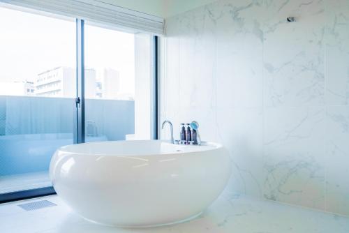 a white sink in a bathroom with a window at Randor Hotel Hiroshima Prestige in Hiroshima
