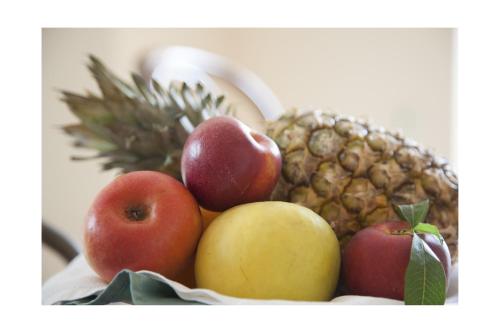 a bowl of fruit with apples and a pineapple at La Dolce Vista - B&B di Charme in Manfredonia