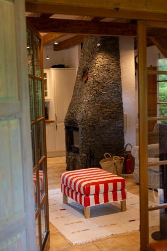 a living room with a fireplace and a red and white stool at Dom Majówka i Apartamenty Bartoszówka i Michałówka in Karwieńskie Błoto Drugie