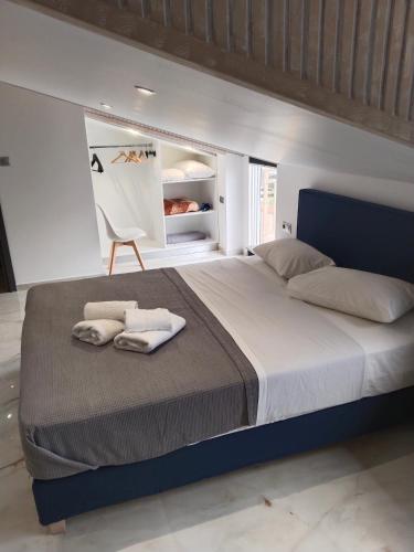 a bedroom with a large bed with towels on it at Hotel Almira in Agia Triada