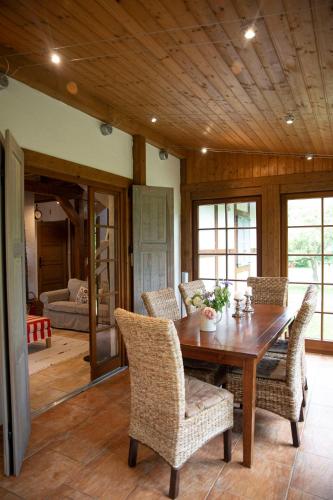 a dining room with a wooden table and chairs at Dom Majówka i Apartamenty Bartoszówka i Michałówka in Karwieńskie Błoto Drugie