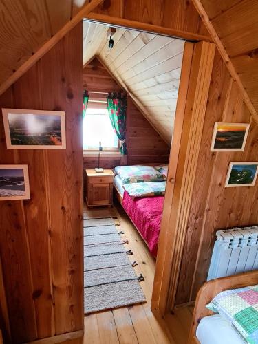 a room with two beds in a log cabin at Domki Pod Horbem in Polańczyk