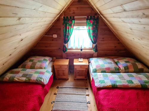 two beds in the attic of a log cabin at Domki Pod Horbem in Polańczyk