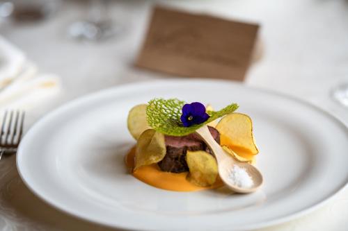 a white plate with a dessert on a table at Hotel Kassian in Lagundo