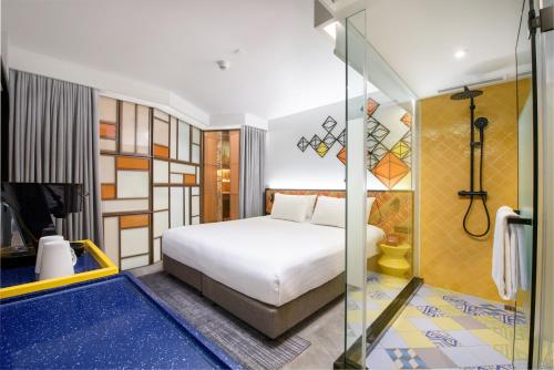 曼谷的住宿－ibis Styles Bangkok Silom，一间卧室设有一张床和一个玻璃淋浴间