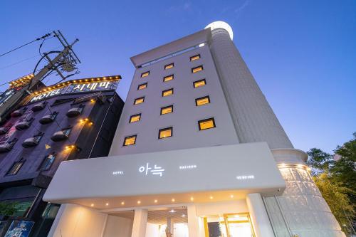 a tall building with a sign in front of it at Aank Hotel Daejeon Yongjeon 2 in Daejeon