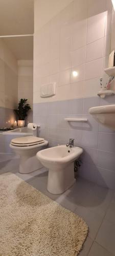 a bathroom with two toilets and a sink and a rug at Nonna Eleonora in Otranto