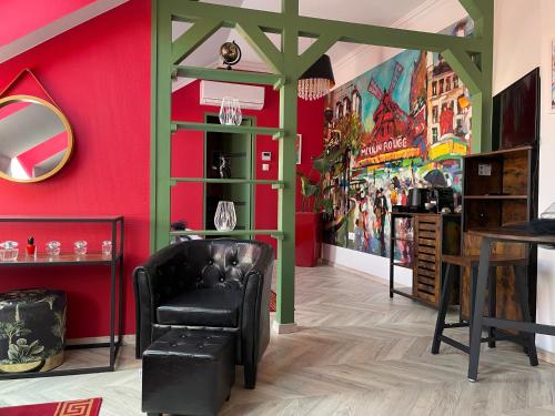 a living room with red walls and a black chair at Dunakavics XIII Apartman in Szentendre