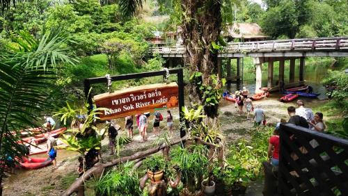 a group of people in a park with a sign at Khao Sok River Lodge Hotel in Khao Sok