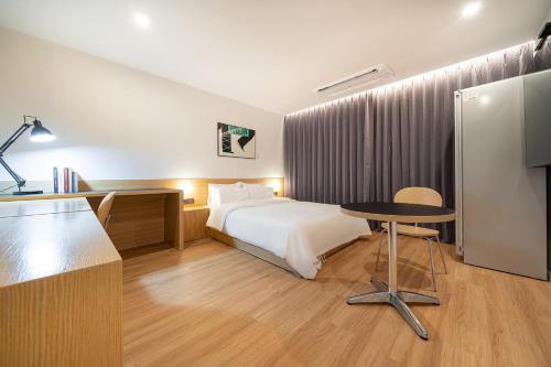 a hotel room with a bed and a table at Aank Hotel Daejeon Yongjeon 2nd in Daejeon