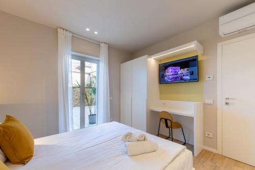 a bedroom with a bed with a tv on the wall at Residenza Betteloni in Bardolino