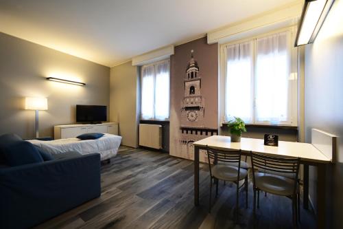 Holiday Homes Aparthotel Milano في ميلانو: غرفة معيشة مع سرير وطاولة وكراسي