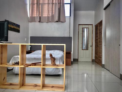 Un dormitorio con una cama y una mesa con una estatua de un gato en Apartamentos Sacor #1 Studio, en Curridabat