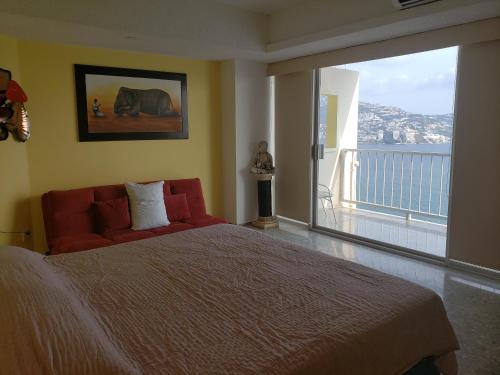a bedroom with a large bed and a large window at PH Torres Gemelas in Acapulco