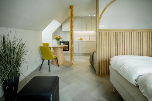 Un dormitorio con una cama y una mesa y una cocina. en Güldenstubbe Residences, en Kuressaare