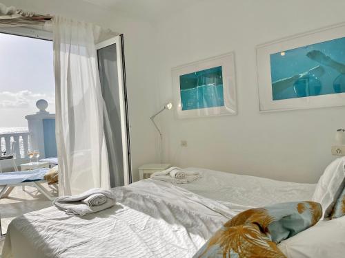 1 Schlafzimmer mit 2 Betten und einem großen Fenster in der Unterkunft Molino Azul 3A, Wohnung mit Meerblick in Valle Gran Rey