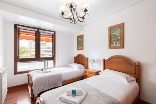 1 dormitorio con 2 camas y ventana en Euromar - baskeyrentals, en Zarautz