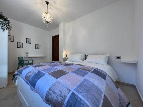 een slaapkamer met een groot bed in een kamer met een kroonluchter bij Gavirate Cozy Apartment BBQ/Garden in Gavirate