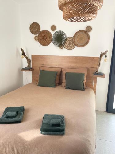 een bed met twee groene handdoeken erop bij Ty kaz : élégant, tout confort et bien situé in Névez