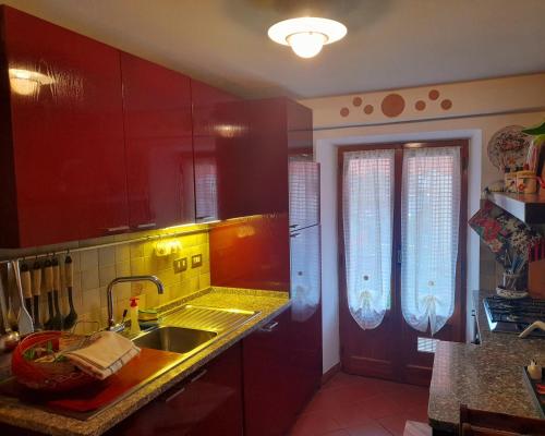 a kitchen with red cabinets and a sink at La Nuova Paranza - Le Grazie - Portovenere - Cinque Terre in Portovenere