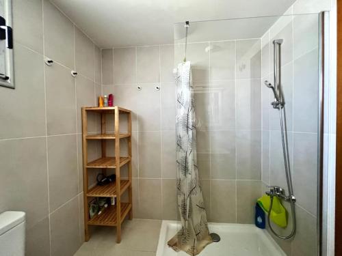 La salle de bains est pourvue d'une douche avec rideau de douche. dans l'établissement Apartment 2 bedrooms and terrace, à La Tejita