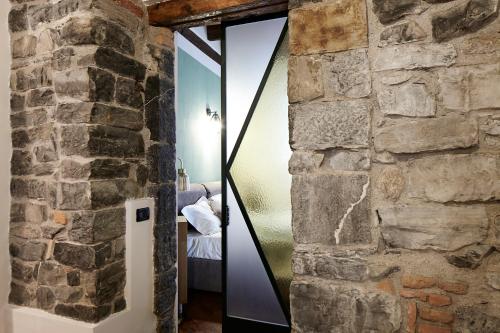 a mirror in a room with a stone wall at Il Moderno by Holiday Solutions in Como