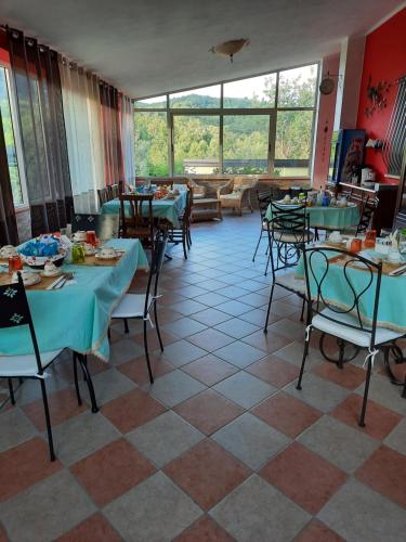 un restaurante con mesas y sillas en una habitación en B&B Cuoreverde Pollino en Rotonda