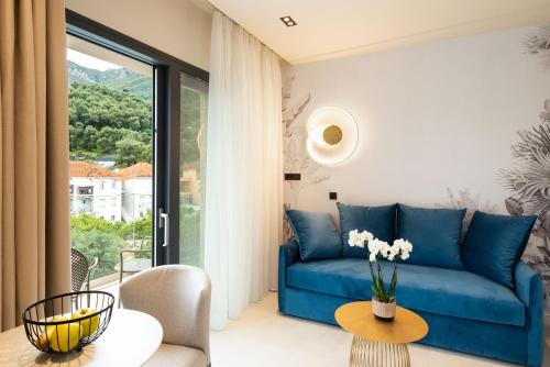 a living room with a blue couch and a table at Hara Suites in Parga