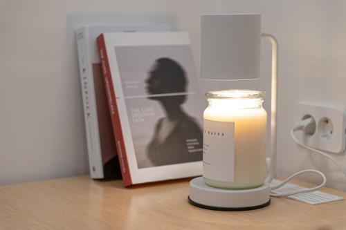 a candle sitting on a table next to a book at Aank Hotel Daejeon Yongjeon 2nd in Daejeon