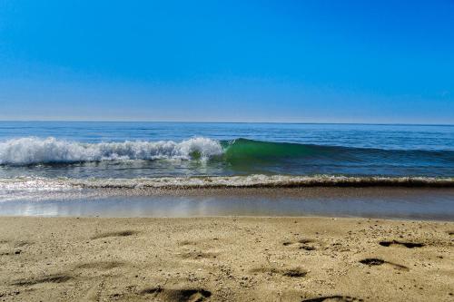 a wave in the ocean on a sandy beach at Domaine de l'Envolée in Tourbes