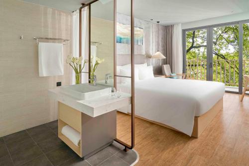 a bedroom with a large white bed and a sink at The Secret Con Dao in Con Dao