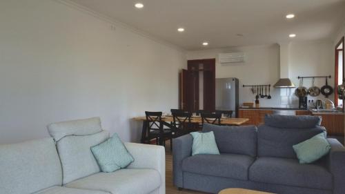 a living room with two couches and a kitchen at Azores Haven Hill in Horta