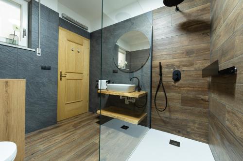 ein Bad mit einem Waschbecken und einem Spiegel in der Unterkunft Ladurner Home in Bruneck