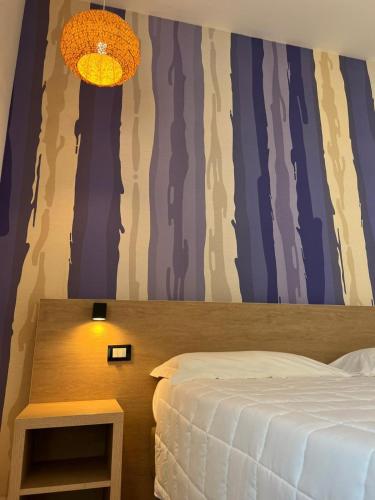a bedroom with a bed and a table with a lamp at Hotel La Martinica in Ficarazzi