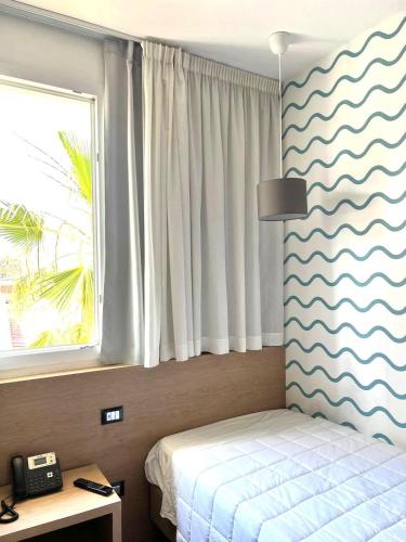 a bedroom with a bed and a window at Hotel La Martinica in Ficarazzi