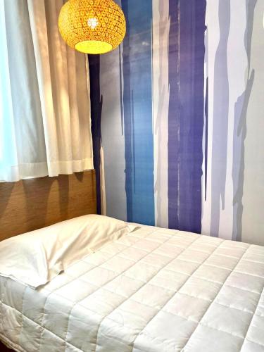 a bedroom with a white bed and a chandelier at Hotel La Martinica in Ficarazzi