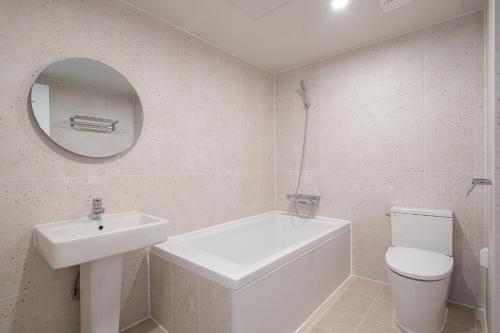 a bathroom with a sink and a toilet and a mirror at Aank Hotel Daejeon Yongjeon 2nd in Daejeon